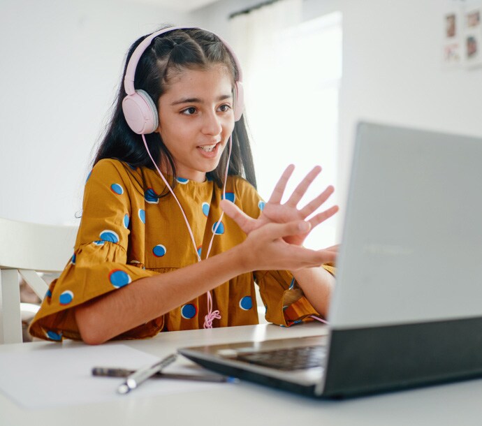 Norton Aileyi başlatan dizüstü bilgisayarı kullanırken masada oturan kız

